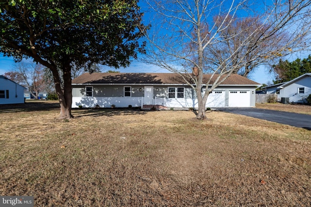 ranch-style house with a garage and a front lawn