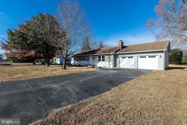 ranch-style house featuring a front yard and a garage