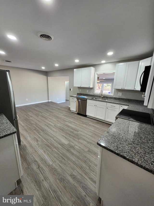 kitchen featuring white cabinetry, sink, stainless steel appliances, and light hardwood / wood-style floors