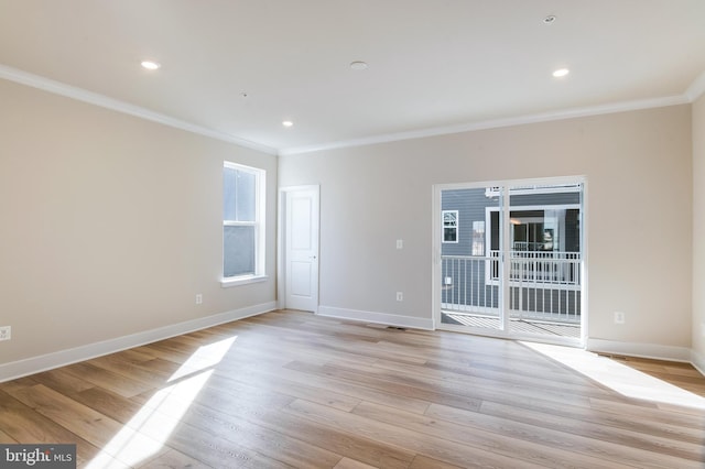 empty room featuring ornamental molding and light hardwood / wood-style flooring