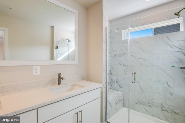 bathroom featuring vanity and a shower with door