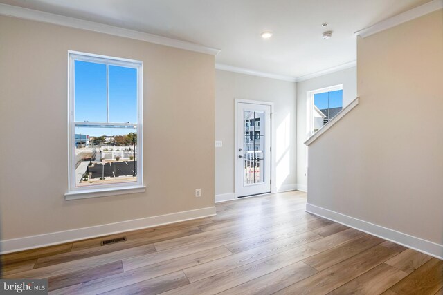 interior space featuring light wood-type flooring and ornamental molding