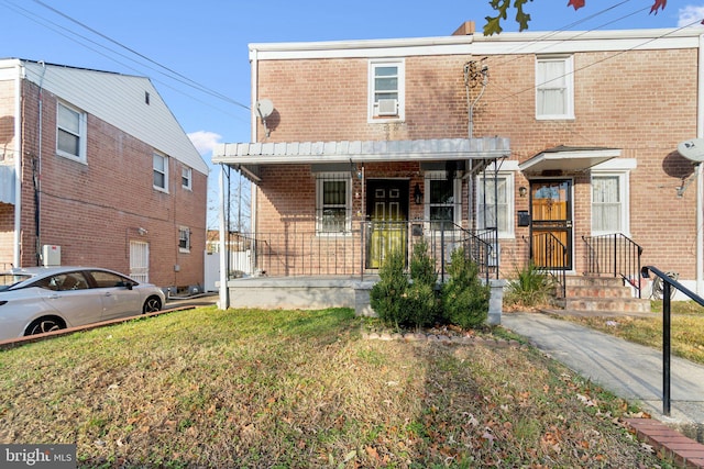 view of front of property featuring covered porch and a front lawn