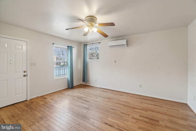 interior space with ceiling fan, light hardwood / wood-style floors, and an AC wall unit