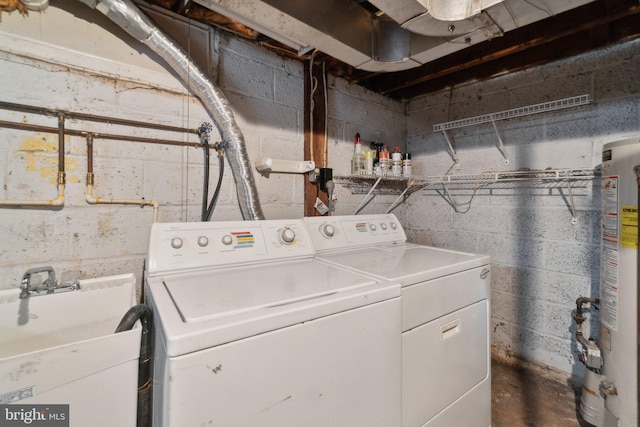 clothes washing area with sink, gas water heater, and washing machine and clothes dryer