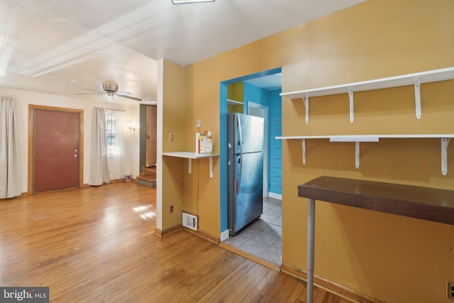 kitchen with light hardwood / wood-style flooring, stainless steel refrigerator, and ceiling fan