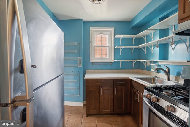 kitchen with light tile patterned flooring, sink, and appliances with stainless steel finishes