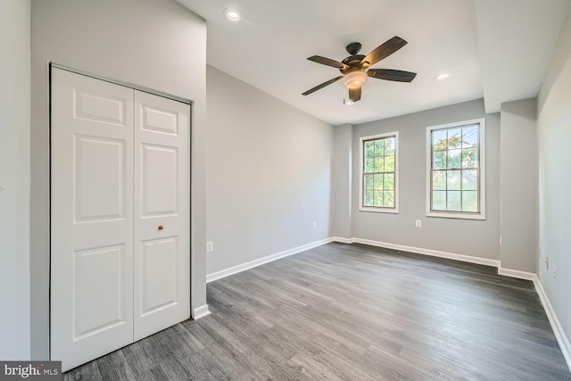 unfurnished bedroom featuring a closet, ceiling fan, and dark wood-type flooring