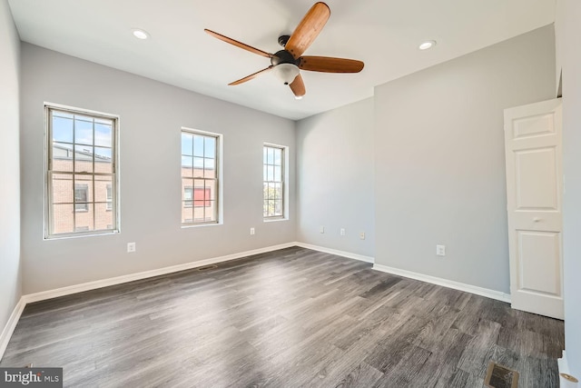 unfurnished room with ceiling fan, a healthy amount of sunlight, and dark hardwood / wood-style floors