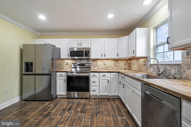 kitchen with butcher block countertops, dark hardwood / wood-style flooring, white cabinetry, and stainless steel appliances