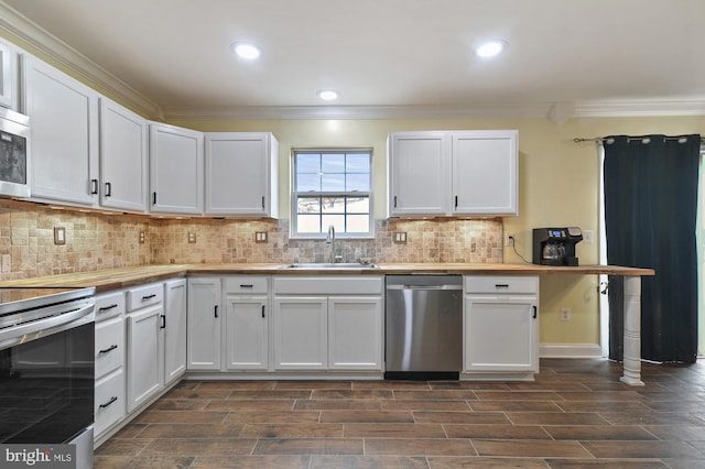 kitchen featuring stainless steel appliances, crown molding, dark wood-type flooring, sink, and white cabinetry