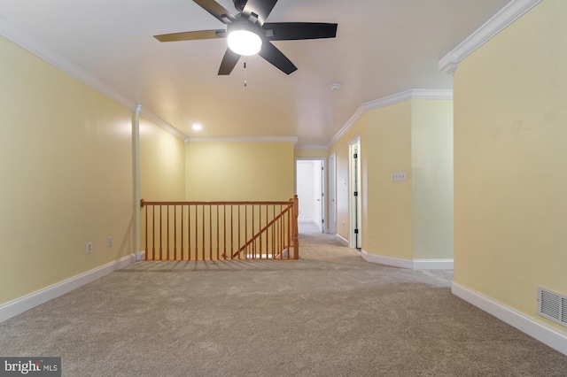 carpeted spare room featuring ceiling fan and ornamental molding