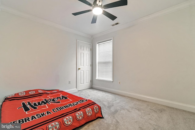 carpeted bedroom with ceiling fan and crown molding