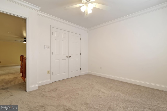 unfurnished bedroom with ceiling fan, ornamental molding, light carpet, and a closet