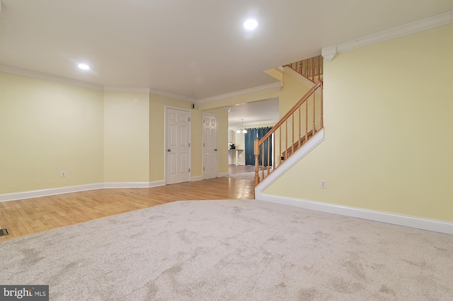 unfurnished living room featuring a chandelier, light wood-type flooring, and ornamental molding