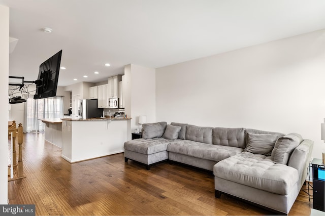 living area with dark wood-type flooring and recessed lighting