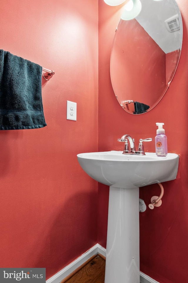 bathroom with visible vents, baseboards, and a sink