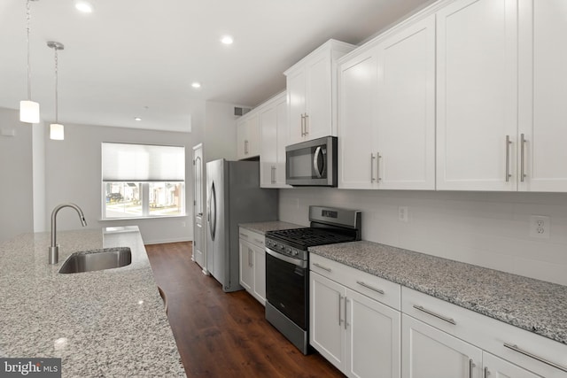 kitchen with light stone counters, white cabinetry, dark wood-type flooring, and appliances with stainless steel finishes