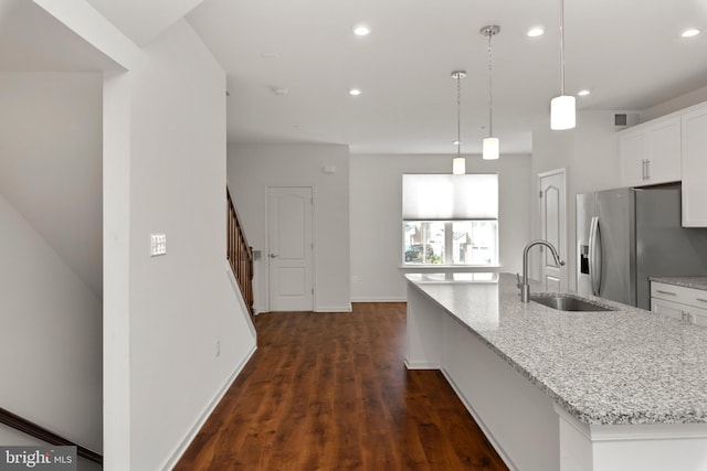 kitchen with white cabinetry, sink, dark wood-type flooring, an island with sink, and pendant lighting