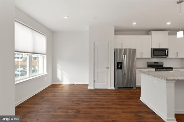 kitchen with stainless steel appliances, tasteful backsplash, dark hardwood / wood-style flooring, decorative light fixtures, and white cabinets