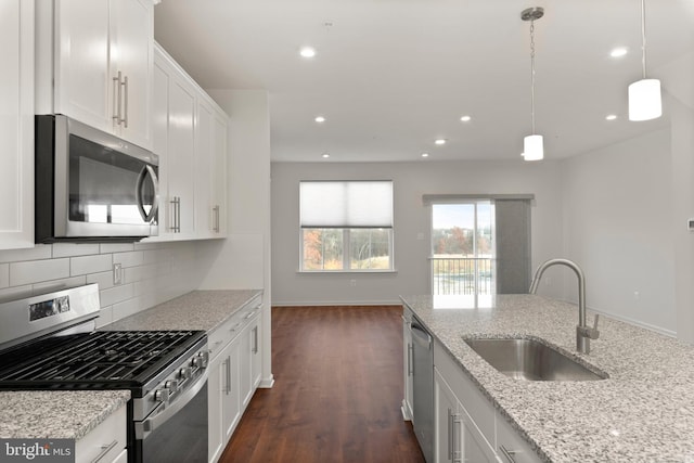 kitchen featuring white cabinetry, sink, light stone countertops, dark hardwood / wood-style flooring, and appliances with stainless steel finishes