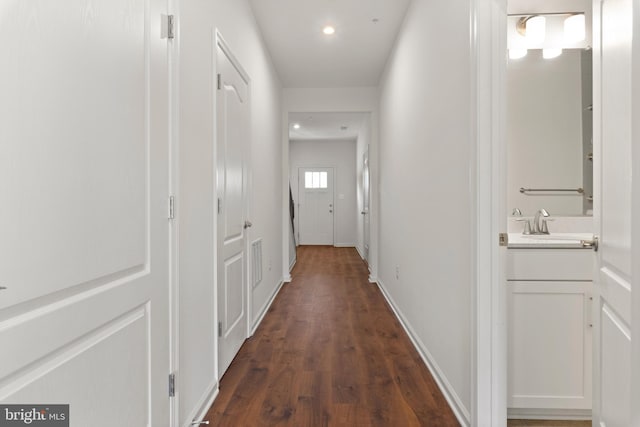 hall with dark hardwood / wood-style flooring and sink