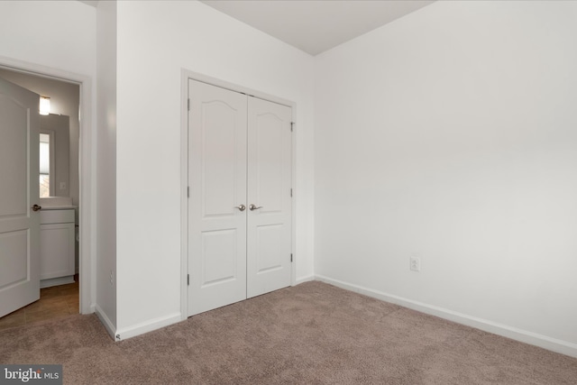 unfurnished bedroom with light carpet and a closet