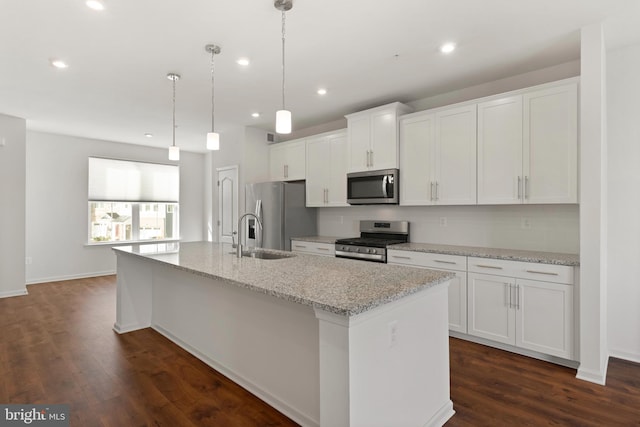 kitchen featuring sink, a center island with sink, hanging light fixtures, and appliances with stainless steel finishes