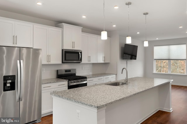 kitchen with white cabinetry, light stone countertops, a center island with sink, and stainless steel appliances