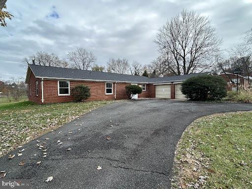 single story home featuring a garage and a front yard