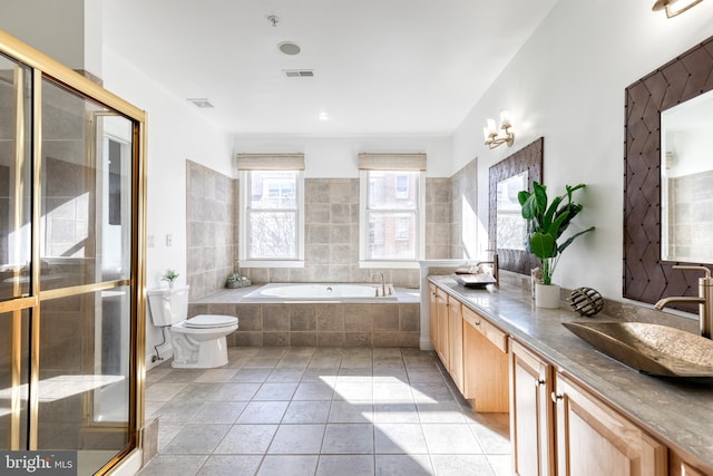 full bathroom featuring toilet, vanity, shower with separate bathtub, and tile patterned flooring