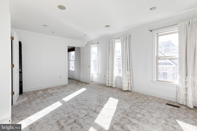 carpeted empty room featuring plenty of natural light