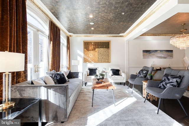 living room featuring crown molding, carpet floors, and a notable chandelier