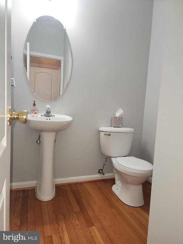 bathroom featuring hardwood / wood-style flooring and toilet