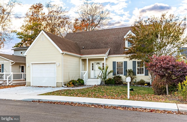 13801 Fountain Rd, Ocean City, MD 21842 - new england style home featuring an attached garage, driveway, a front yard, and covered porch