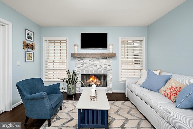 13801 Fountain Rd, Ocean City, MD 21842 - living area with wood finished floors, healthy amount of natural light, a glass covered fireplace, and baseboards