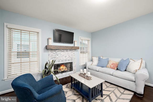 13801 Fountain Rd, Ocean City, MD 21842 - living area with wood finished floors, a tiled fireplace, and baseboards