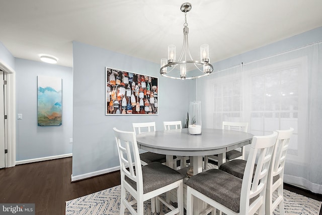 dining room featuring dark hardwood / wood-style flooring and an inviting chandelier