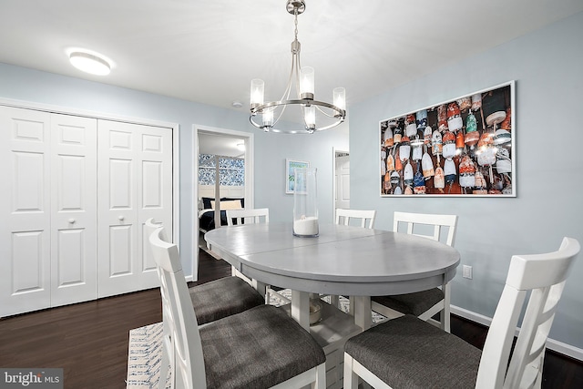 dining space featuring dark hardwood / wood-style flooring and a chandelier