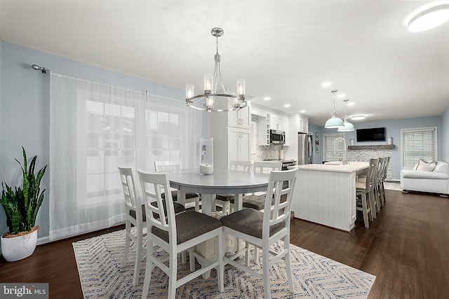 dining space with dark hardwood / wood-style flooring and an inviting chandelier