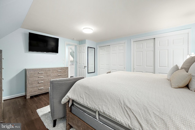 bedroom featuring two closets and dark hardwood / wood-style floors