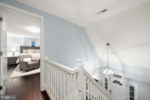 hallway with a chandelier and dark hardwood / wood-style floors