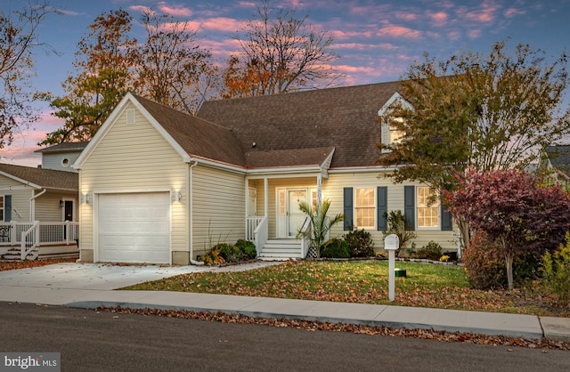 new england style home with a yard and a garage