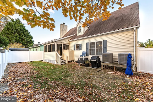 13801 Fountain Rd, Ocean City, MD 21842 - rear view of house featuring a sunroom, central AC unit, a fenced backyard, and a chimney