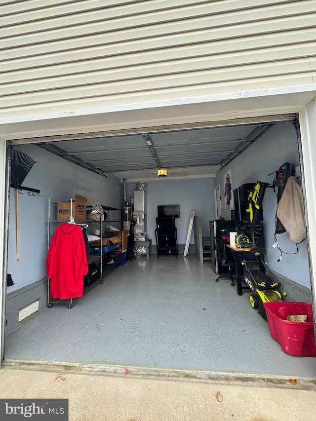 garage featuring strapped water heater and a garage door opener