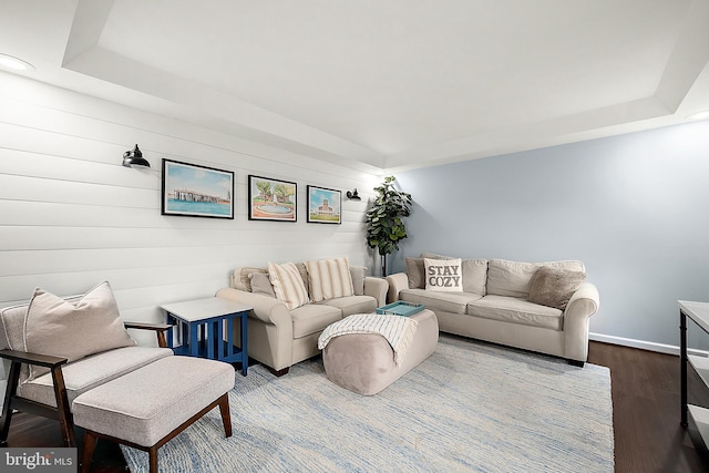 living room with a tray ceiling and hardwood / wood-style floors