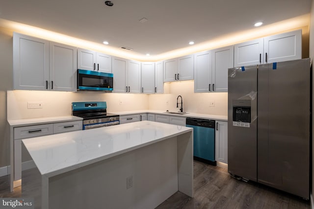 kitchen with stainless steel appliances, white cabinetry, dark wood-type flooring, and sink