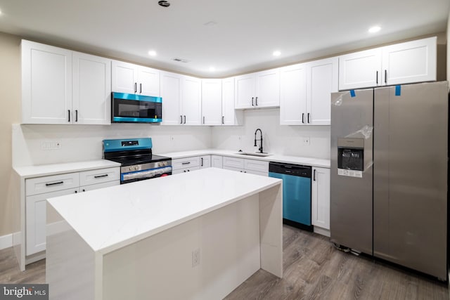 kitchen featuring a center island, stainless steel appliances, white cabinetry, and dark hardwood / wood-style floors