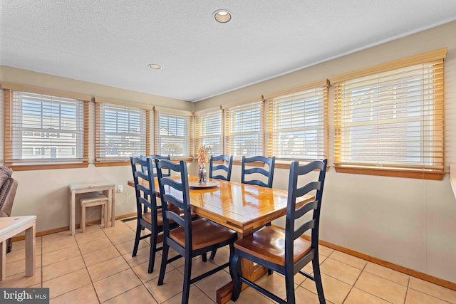 dining space featuring light tile patterned floors and a textured ceiling