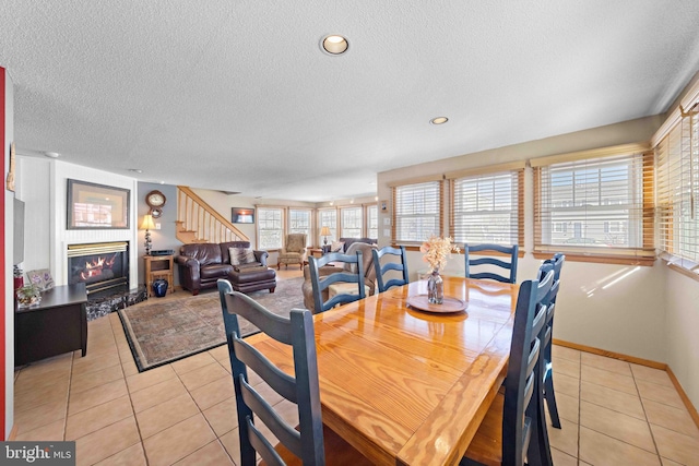 dining space featuring light tile patterned flooring and a textured ceiling